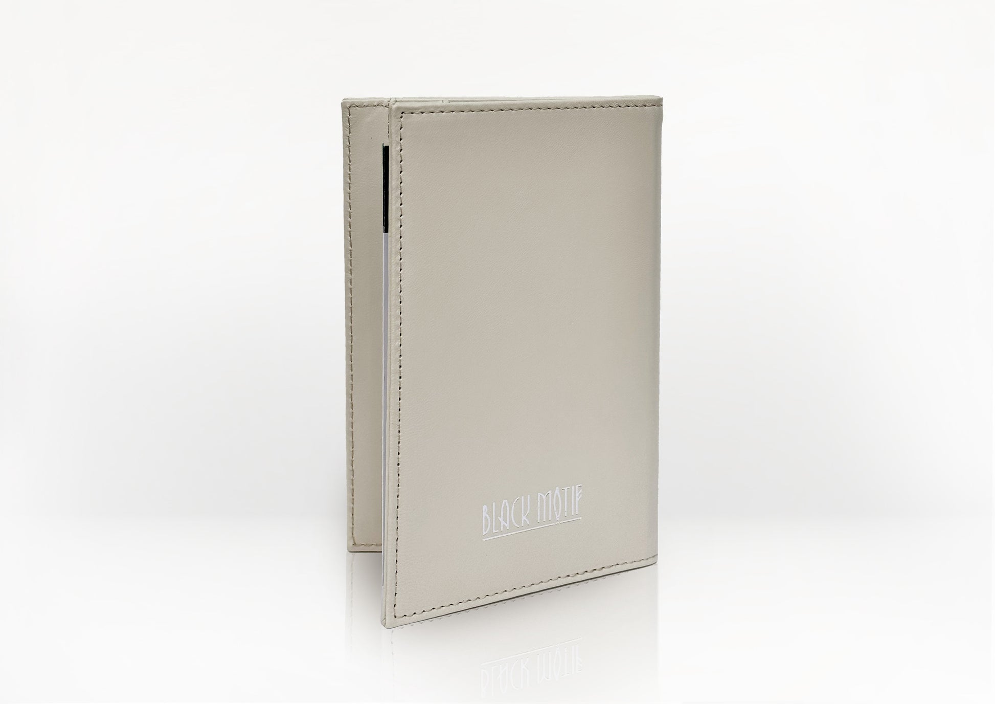 Side profile of the Carte du Jeu scorecard holder in matte light beige calfskin, showcasing fine stitching and slim handcrafted design.