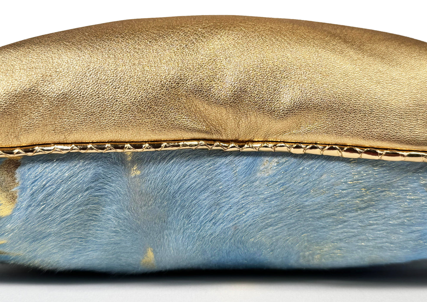 Close-up of the gold sheepskin, blue calf leather with gold patina, and pink hair-on-hide from the Fleurie cushion.