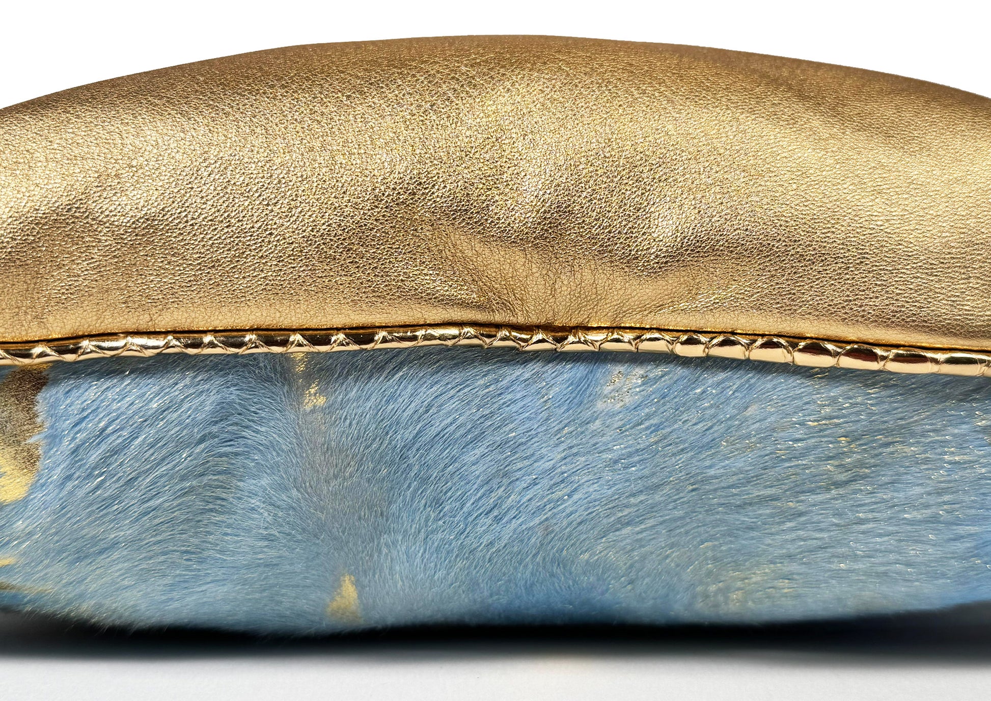 Close-up of the gold sheepskin, blue calf leather with gold patina, and pink hair-on-hide from the Fleurie cushion.