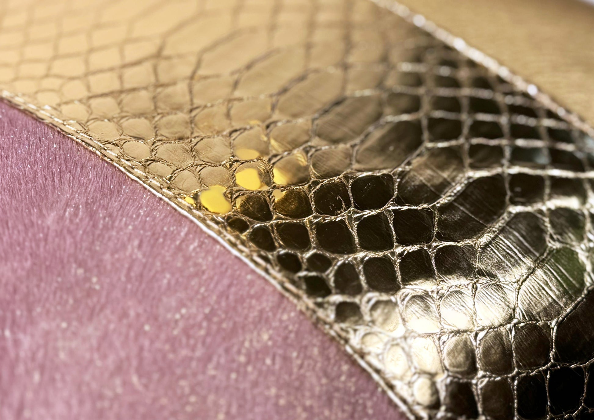 Close-up of the glazed golden python leather insert on the Lolita cushion, showing texture and soft contrast with pink and gold tones.