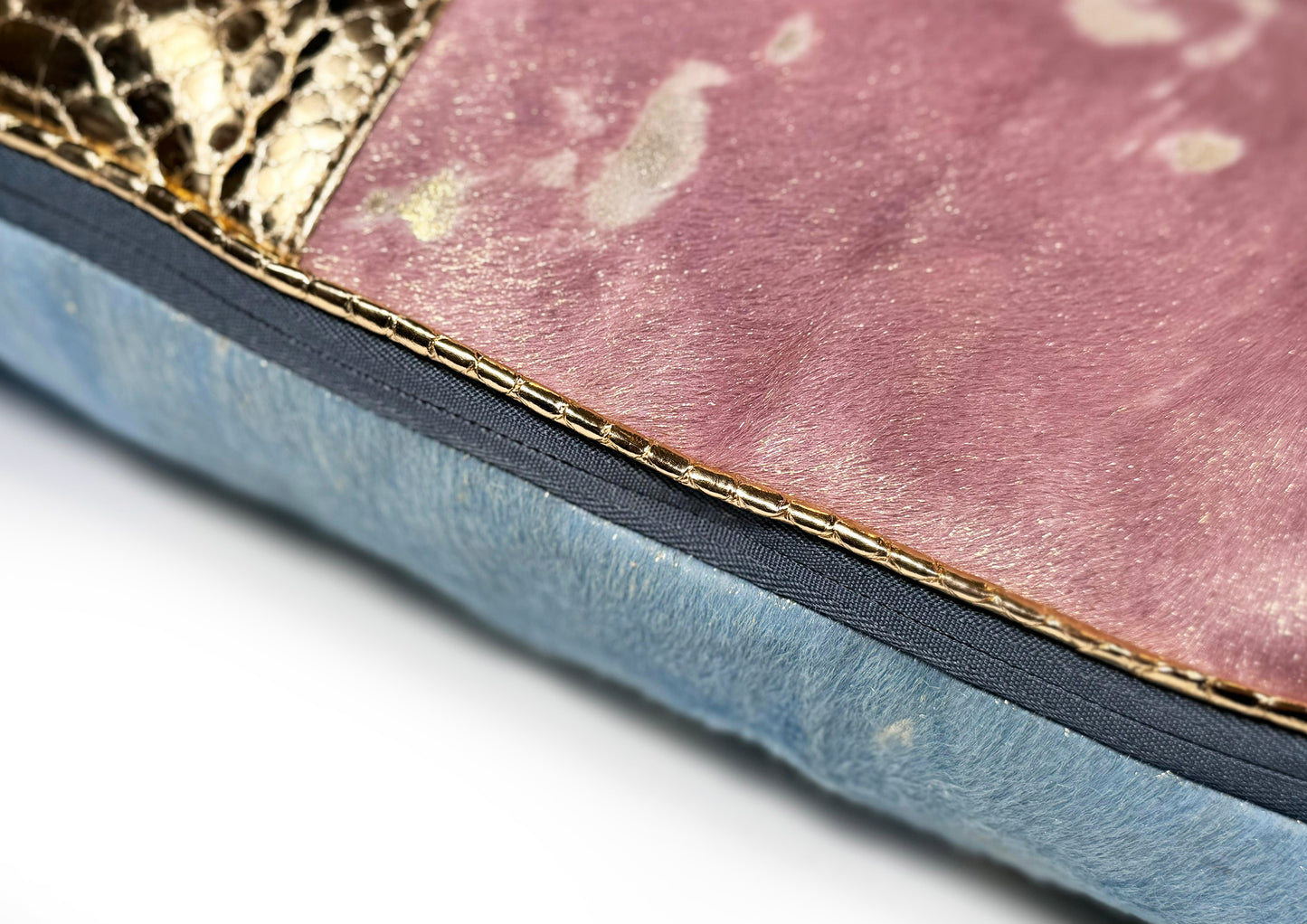 Close-up of the blue zipper detail on the Lolita luxury cushion, crafted from pink-gold calf, golden python, and sheepskin.