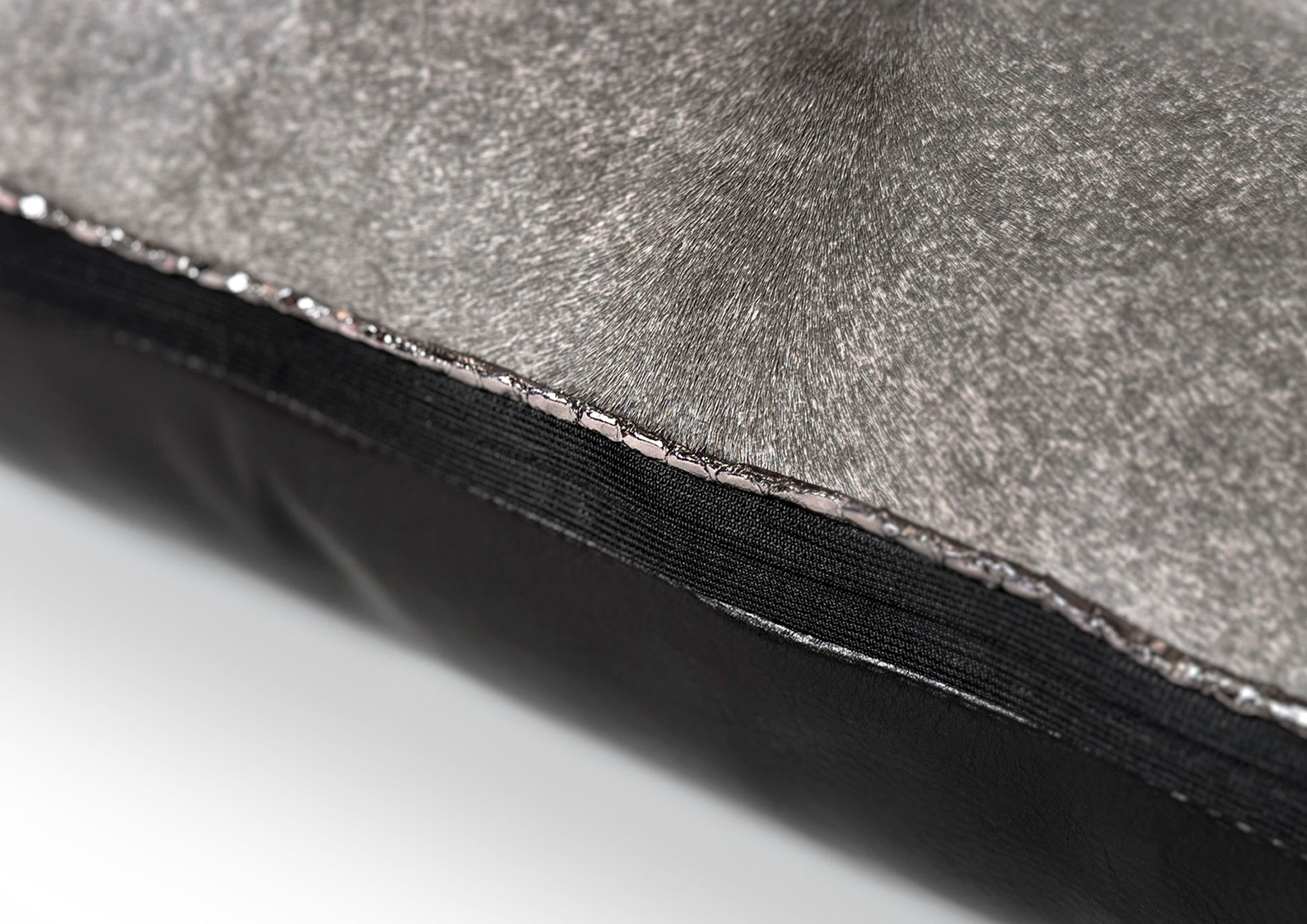 Close-up of the black zipper on the Metropolitan Small luxury cushion, crafted in grey hair-on-hide and black calf leather.