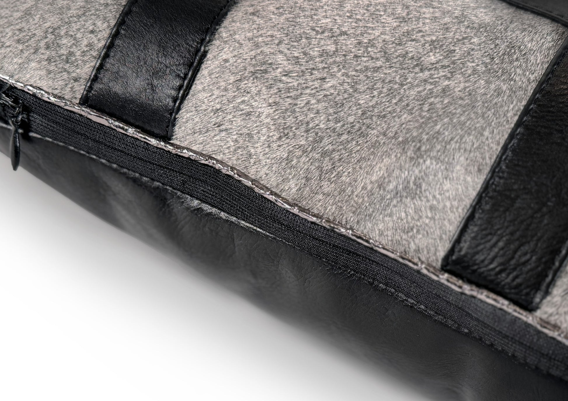 Detail of the black calf leather stripes forming geometric squares on the grey hair-on-hide front of the Metropolitan Large Square cushion.