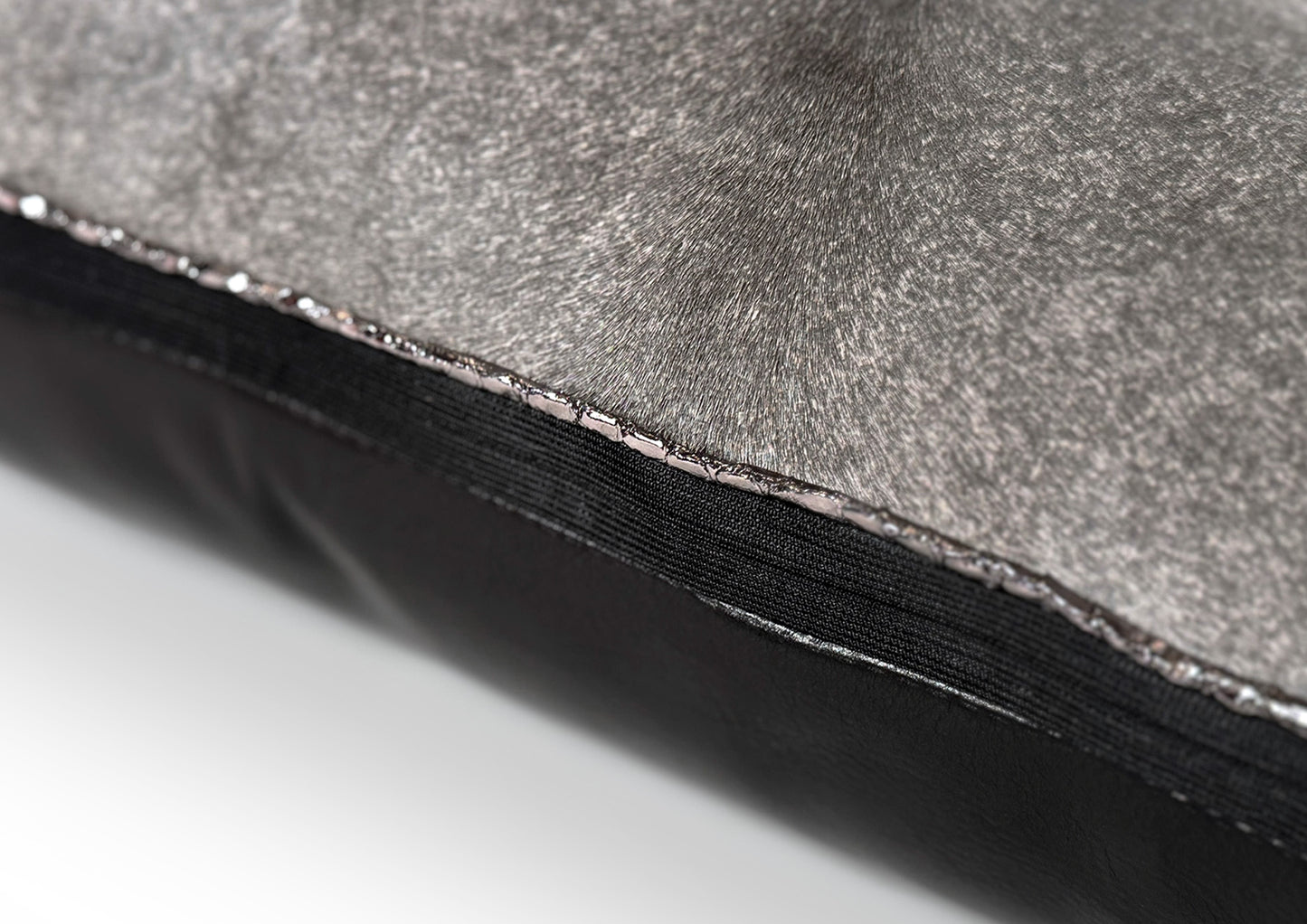Close-up of the black zipper on the Metropolitan Large Square cushion, crafted from grey hair-on-hide and black calf leather.