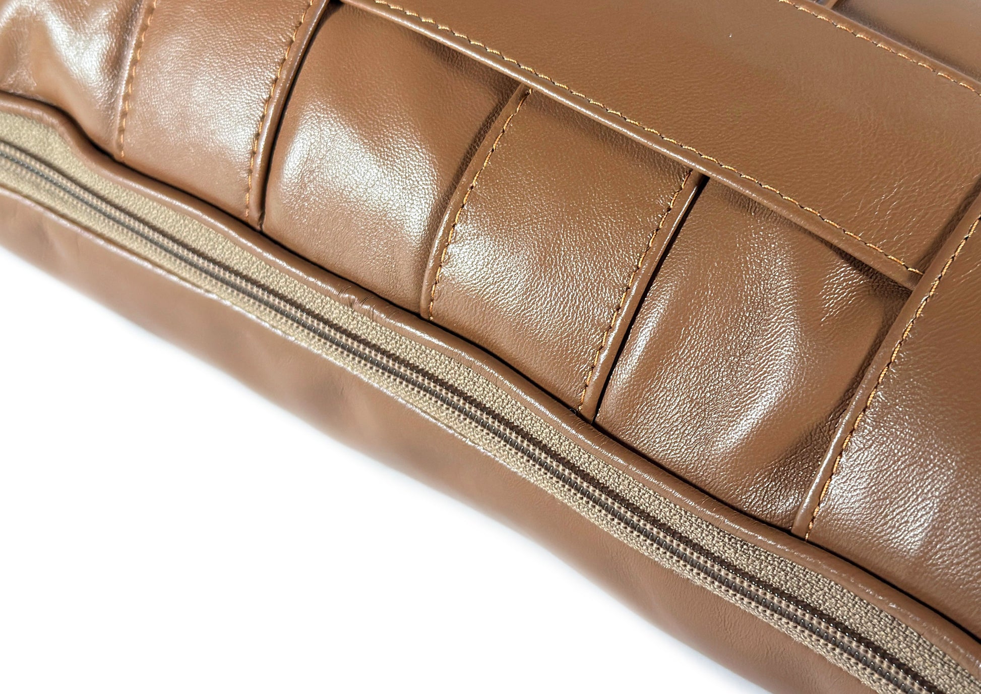 Close-up of the hidden zipper on the Terracotta Stripe Large cushion, crafted from caramel and ivory leather.