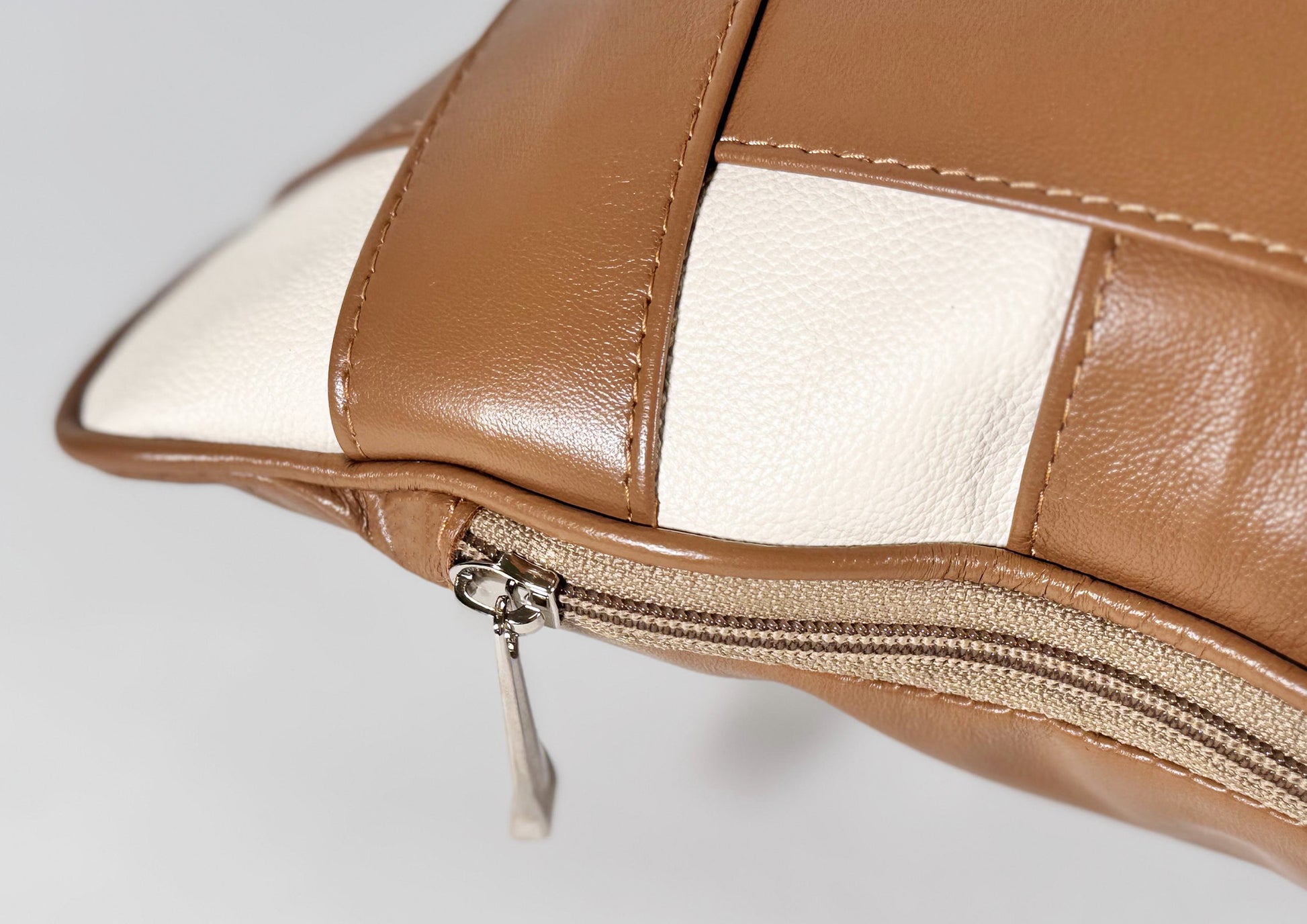 Close-up of the natural Terracotta Tan goat leather and Soft Ivory calf leather textures from the Terracotta Weave Small cushion.